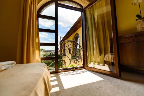 1 dormitorio con puerta abierta a un balcón en Pension Passion, en Târgu Mureș