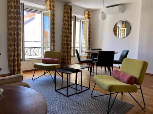 un salon avec des chaises, une table et des fenêtres dans l'établissement LE BAIN DE SOLEIL luxury 2 bedrooms Cannes centre, à Cannes