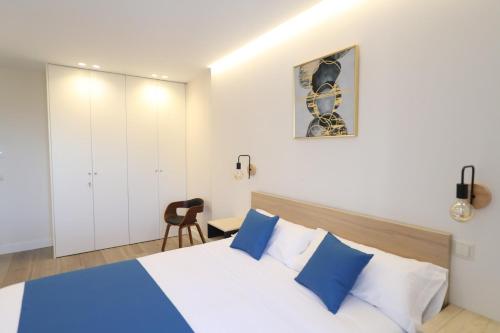 a bedroom with a bed with blue and white pillows at San Vicente Apartments in Avila