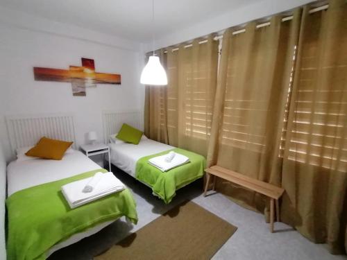 - 2 lits dans une chambre avec des draps verts dans l'établissement Del Parque Flats - Guadalmar - Beach & Relax, à Malaga