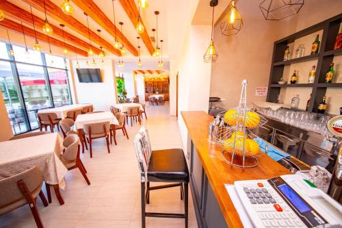 a restaurant with a bar and tables and chairs at Hotel Miki in Durrës