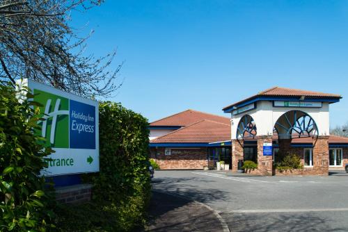 a building with a sign in front of it at Holiday Inn Express Peterborough by IHG in Peterborough