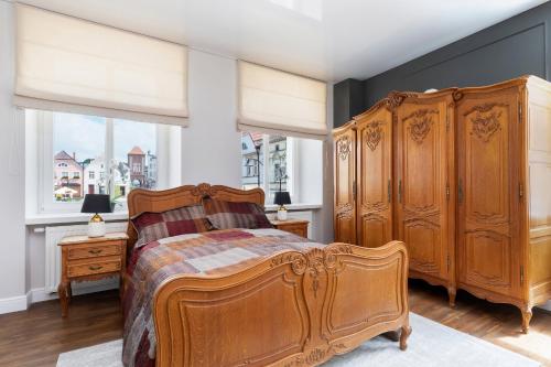a bedroom with a large wooden bed and a window at Apartament Premium na Rynku by Renters Prestige in Darłowo