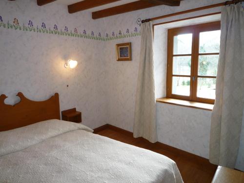 a bedroom with a bed and a window at Domaine Véga in Saint-Arroman