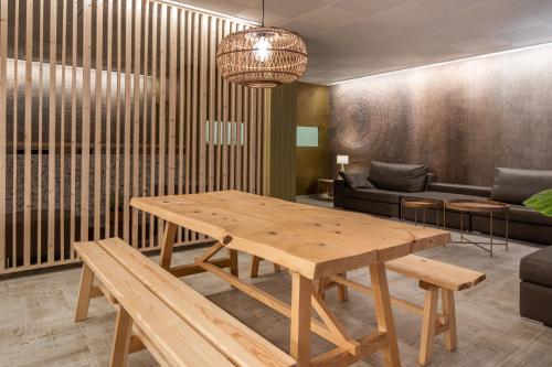 sala de estar con mesa de madera y sofá en Hostal Residencia Nicolau, en San Antonio