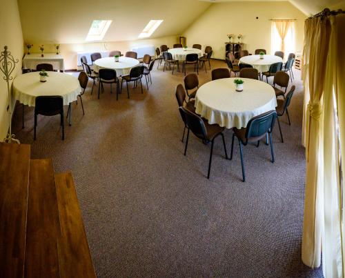 a room filled with tables and chairs with white tablecloths at Pension Passion in Târgu-Mureş