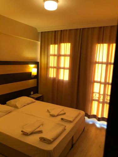 a bedroom with a bed with two towels on it at Sun Hotel in Çeşme
