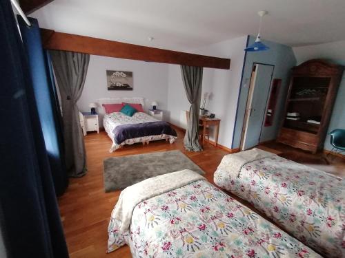 a bedroom with two beds in a room at La Parisiere in Gavray