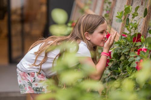 a little girl picking flowers from a bush at Getaria Apartamentuak - Balentziaga in Getaria