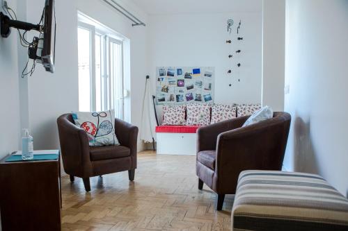 sala de estar con 2 sillas y sofá en Casa das Aguarelas - Apartamentos, en Ericeira