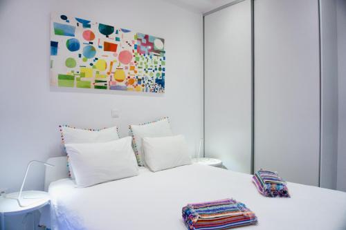 1 dormitorio con 1 cama blanca y una pintura en la pared en Amazing Modern Central Apt in Athens en Athens