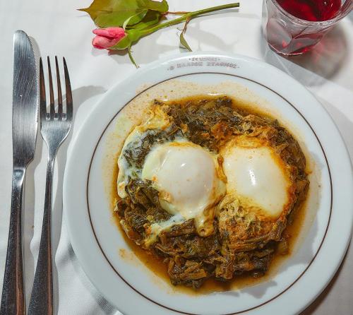 a plate of food with an egg on a table at Palios Stathmos in Miléai