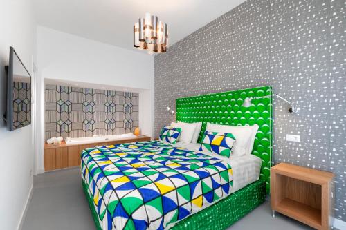 a bedroom with a bed with a green headboard at Luxury Design Home & Jacuzzi in Heart of Sorrento in Sorrento