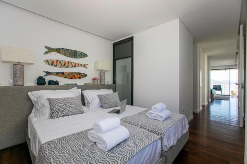 a bedroom with a large bed with towels on it at LovelyStay - Luxury 2BR Duplex Apartment in Foz Porto in Porto