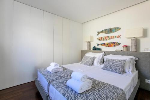 a bedroom with two beds with towels on them at LovelyStay - Luxury 2BR Duplex Apartment in Foz Porto in Porto