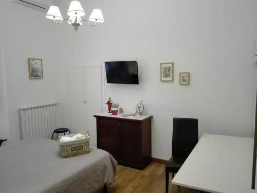 a bedroom with two beds and a tv on the wall at Napoli Pietrasanta LT in Naples