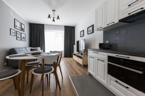 a kitchen and living room with a table and chairs at Symphony Baltica Towers Apartamenty in Gdańsk