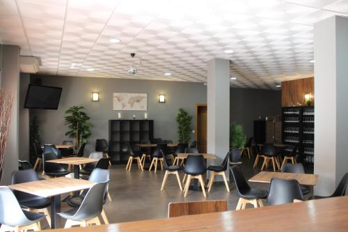 a dining room with tables and chairs and a tv at Hotel Valdemoro in Valdemoro