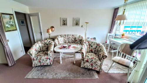 ein Wohnzimmer mit 2 Stühlen und einem Tisch in der Unterkunft Apartment Seaside in Westerland