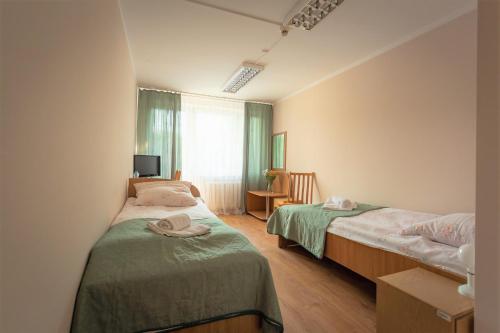 1 dormitorio con 2 camas y ventana en Hotel Sybilla, en Puławy