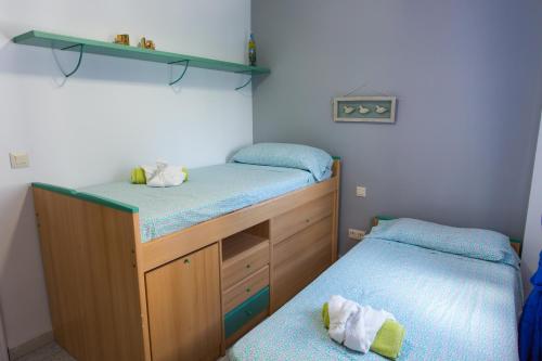 1 dormitorio con 2 camas individuales y estanterías en Torre Almadraba- Turistika, en Denia