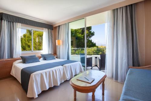 pokój hotelowy z łóżkiem i dużym oknem w obiekcie Grupotel Natura Playa w Playa de Muro