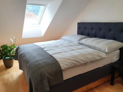 uma cama com uma cabeceira azul num quarto com uma janela em Dachgeschoss-Apartment in Landeck - 140m² em Landeck
