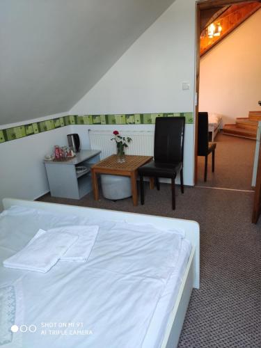 a bedroom with a bed and a table and chairs at Poddasze in Zblewo