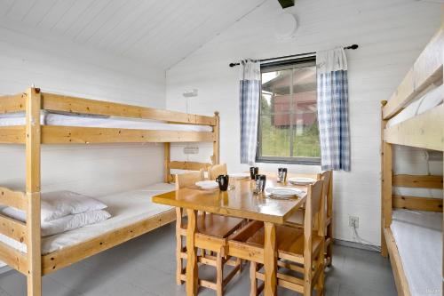 a room with a table and bunk beds at First Camp Frösön-Östersund in Frösö
