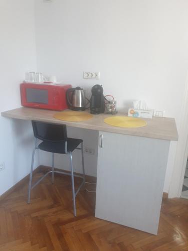 a kitchen counter with a microwave and a table at Studio Yellow - Piata Victoriei in Bucharest