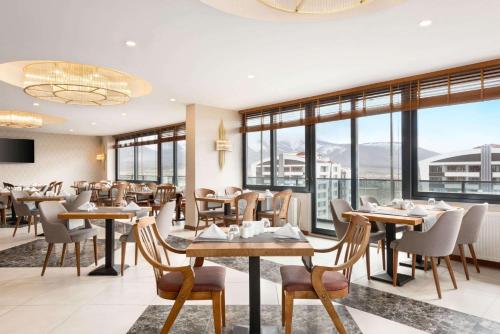 un ristorante con tavoli, sedie e finestre di Ramada by Wyndham Nigde a Nigde