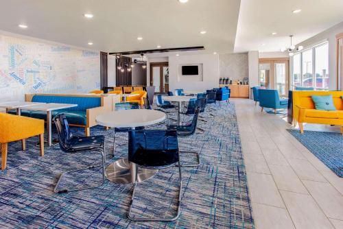 a cafeteria with tables and chairs and a map on the wall at La Quinta by Wyndham San Antonio Alamo City in San Antonio