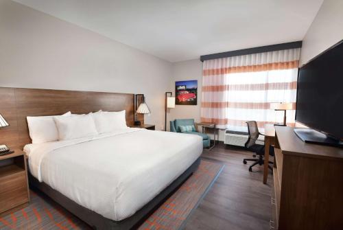 a hotel room with a bed and a desk and a television at La Quinta Inn & Suites by Wyndham Wisconsin Dells- Lake Delton in Wisconsin Dells