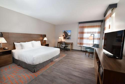 a hotel room with a bed and a flat screen tv at La Quinta Inn & Suites by Wyndham Wisconsin Dells- Lake Delton in Wisconsin Dells