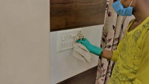 阿格拉的住宿－Hotel Marwari，戴面具和手套的女人擦墙