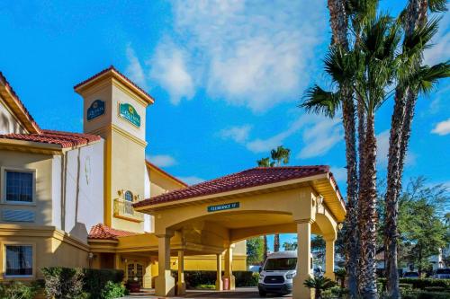 a building with a clock tower and palm trees at La Quinta by Wyndham Tucson Airport in Tucson