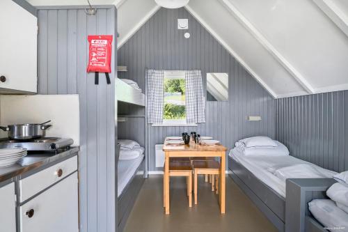 a kitchen with two beds and a table in a room at First Camp Frösön-Östersund in Frösö