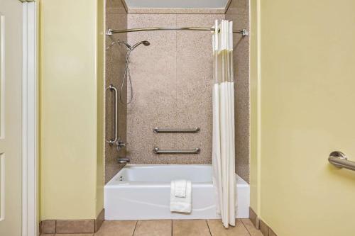 W łazience znajduje się prysznic i biała wanna. w obiekcie La Quinta by Wyndham Moreno Valley w mieście Moreno Valley