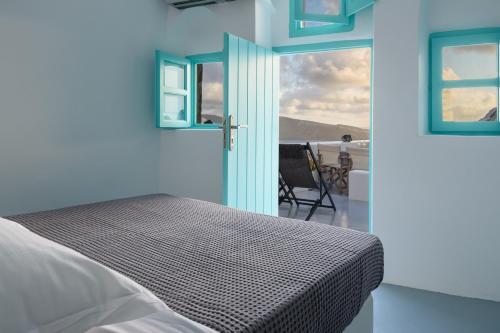 1 dormitorio con cama y vistas al océano en Cave Agapi, en Oia
