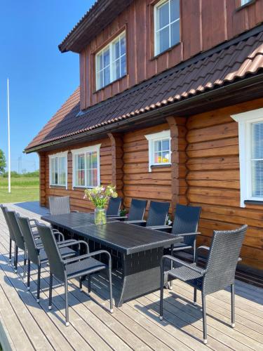 a wooden deck with a black table and chairs at Rosi Puhkemaja in Koljala