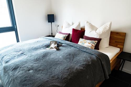 a bedroom with a bed with a blue blanket and pillows at Ferienhäuser Saalemaxx in Rudolstadt