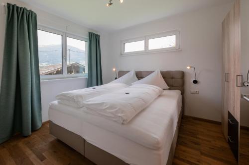 1 cama blanca grande en una habitación con ventanas en Appartement PIA, en Schönberg im Stubaital