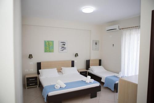 a hotel room with two beds in a room at Perivolos Apartments in Dhërmi