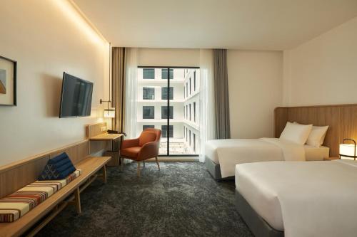a hotel room with two beds and a television at ASAI Bangkok Chinatown in Bangkok
