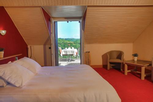 a bedroom with a large white bed and a table at L'Oustal Del Barry in Najac