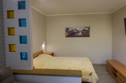- une chambre avec un lit et une photo sur le mur dans l'établissement Уютная VIP-студия в центре., à Vinnytsia