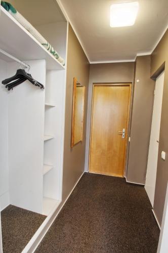 a hallway with a wooden door and shelves at Vila Kastytis in Nida