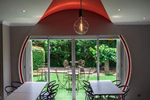 a dining room with tables and chairs and a large mirror at Hotel Le Quetzal in La Grande-Motte