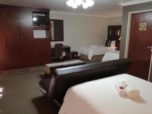 a hotel room with a bedroom with two beds at Belmont Guesthouse in Bloemfontein