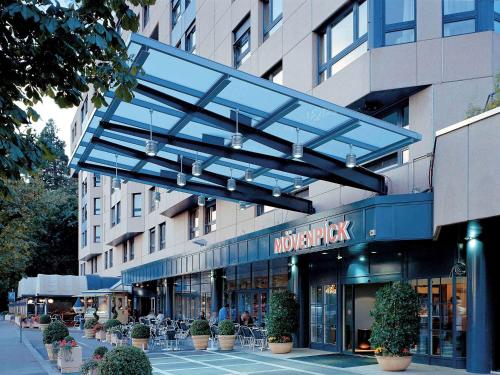 un bâtiment avec un auvent bleu au-dessus d'un magasin dans l'établissement Mövenpick Hotel Lausanne, à Lausanne